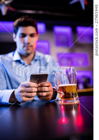 Man using mobile phone at bar counter 27965948