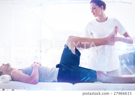 Composite image of physiotherapist massaging leg of man Composite image of physiotherapist massaging leg of man 27966615