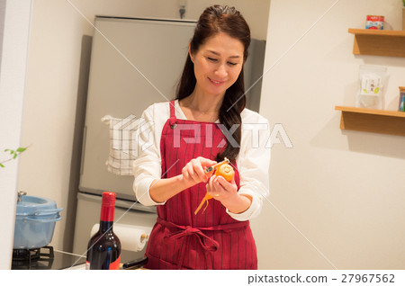 A middle woman standing in a bright kitchen 27967562