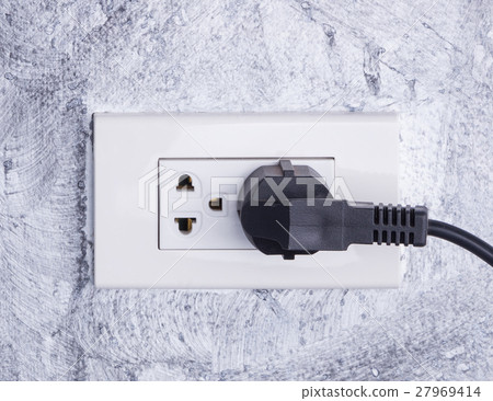 cable plugged in a white electric outlet mounted 27969414