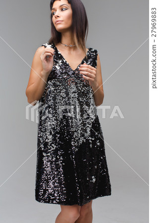Girl in black dress with sequins looking away 27969883