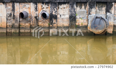 Water discharge pipe  canal in the city 27974902