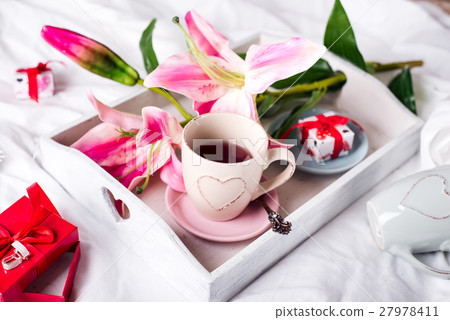 tray with cup of hot tea in the bed, 27978411