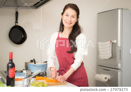 站立在一個明亮的廚房裡的中間婦女 27979273