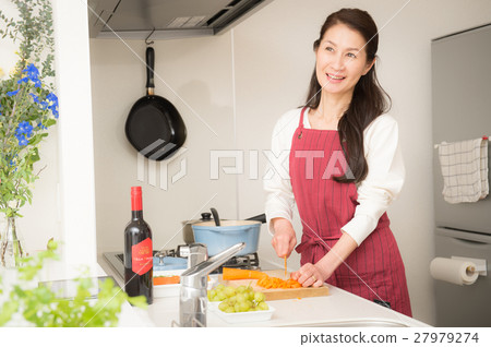 站立在一個明亮的廚房裡的中間婦女 27979274