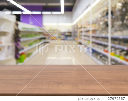 Brown empty table in front of blurred supermarket Brown empty table in front of blurred supermarket 27979367