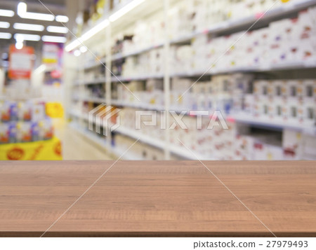 Brown empty table in front of blurred supermarket Brown empty table in front of blurred supermarket 27979493