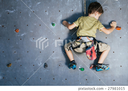 little boy climbing a rock wall indoor little boy climbing a rock wall indoor 27981015
