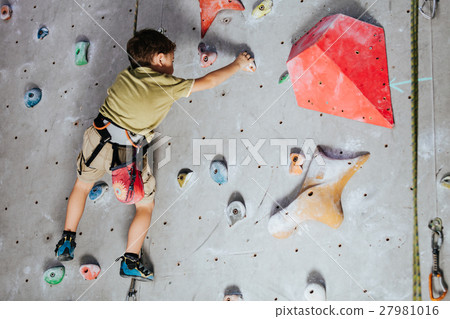 little boy climbing a rock wall indoor little boy climbing a rock wall indoor 27981016