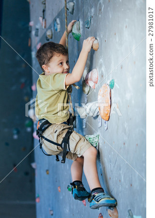 little boy climbing a rock wall indoor little boy climbing a rock wall indoor 27981017