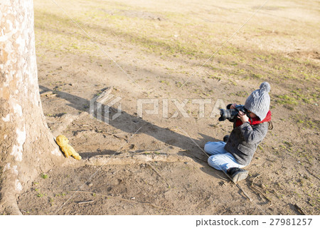 Girl taking pictures of bear's sewing package Girl taking pictures of bear's sewing package 27981257