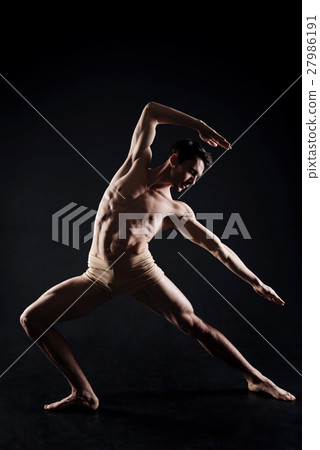 Handsome man practicing yoga in the dark lighted Handsome man practicing yoga in the dark lighted 27986191