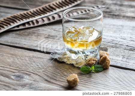 Glass of rum on the wooden background 27986803