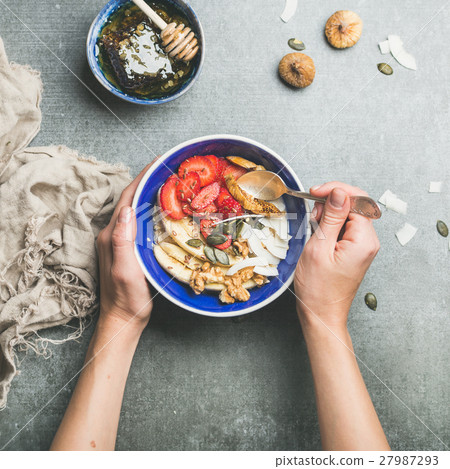 Eating healthy breakfast bowl over grey concrete 27987293