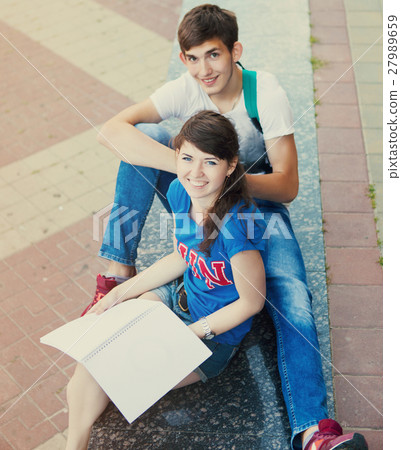 Two students or teenagers with notebooks outdoors Two students or teenagers with notebooks outdoors 27989659