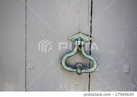 Old door knocker on an old wooden entrance door Old door knocker on an old wooden entrance door 27989689