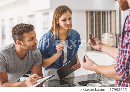 Man holding small bottle with dark liquid 27992635