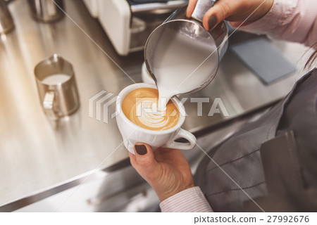 Woman filling cup of coffee Woman filling cup of coffee 27992676