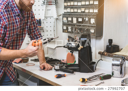 Bearded serious man holding drill Bearded serious man holding drill 27992707