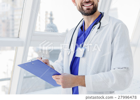 Cheerful male physician making notes Cheerful male physician making notes 27996478