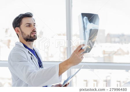 Smart male general practitioner looking at Smart male general practitioner looking at 27996480