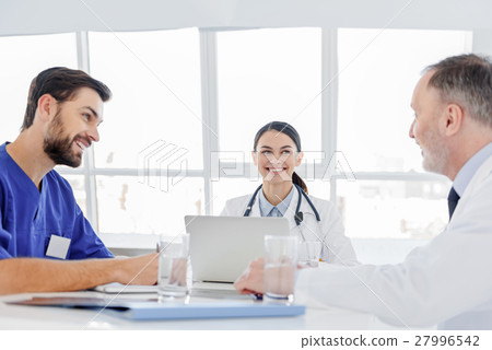 Cheerful doctors discussing human health with 27996542
