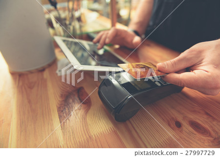 Barista taking credit card to do payment for 27997729