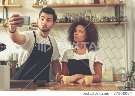 Two friendly co-workers creating images on mobile 27998094