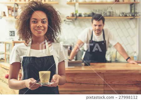 Waitress holding cup of delicious latte in hands 27998112