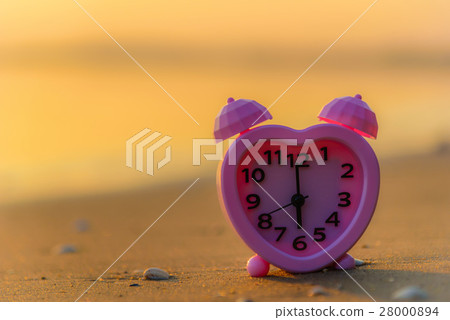 Pink clock on the beach at sunset. Pink clock on the beach at sunset. 28000894