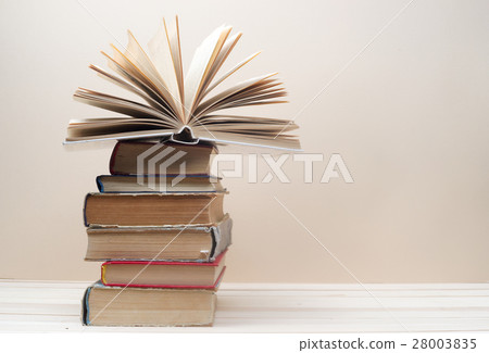 Open book, stack of hardback books on wooden table Open book, stack of hardback books on wooden table 28003835