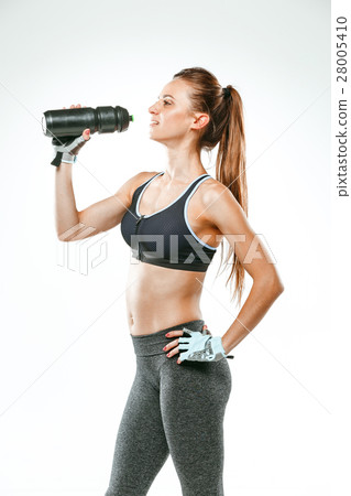 Muscular young woman athlete with a water on black 28005410