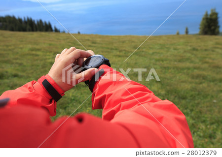 hiker checking the altimeter on sports watch hiker checking the altimeter on sports watch 28012379