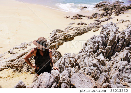 Girl in the hat on the rocky beach 28013280