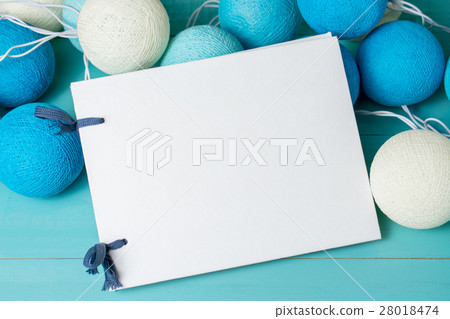 Blank notebook with garland on blue background 28018474
