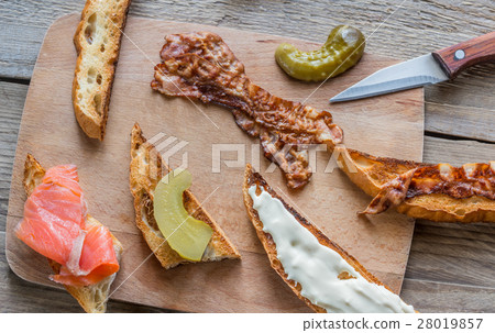 Toasts with different toppings on the wooden board Toasts with different toppings on the wooden board 28019857