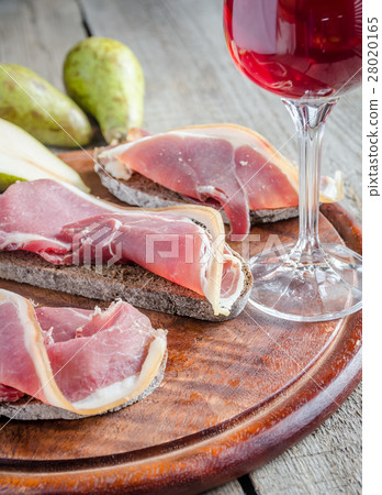 Slices of italian ham on the wooden board 28020165