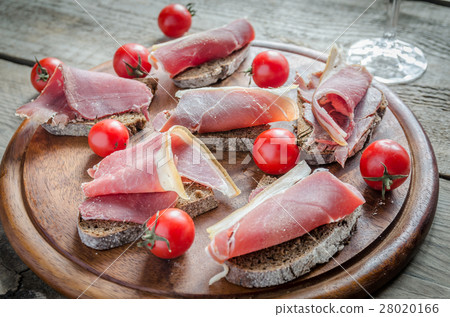 Slices of italian ham on the wooden board Slices of italian ham on the wooden board 28020166