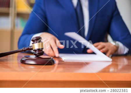 Handsome judge with gavel sitting in courtroom Handsome judge with gavel sitting in courtroom 28022381