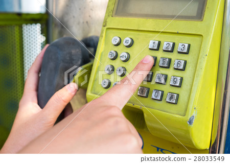 Dialing a payphone Dialing a payphone 28033549