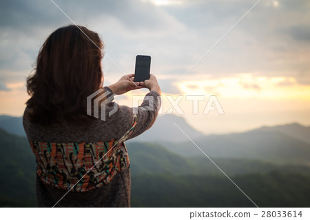 Young woman take photo of mountain by smartphone Young woman take photo of mountain by smartphone 28033614