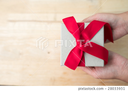 Gift box with red ribbon on wooden table 28033931