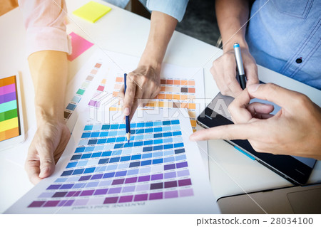 Graphic designers meeting to discuss new ideas at office. Team w Graphic designers meeting to discuss new ideas at office. Team w 28034100