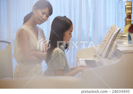 A girl who receives a piano lesson A girl who receives a piano lesson 28034895
