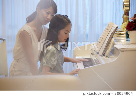 A girl who receives a piano lesson A girl who receives a piano lesson 28034904