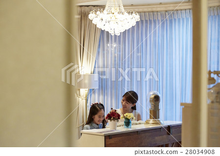 A girl who receives a piano lesson 28034908