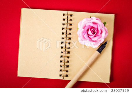 Open empty diary and pen with rose on red. Open empty diary and pen with rose on red. 28037539