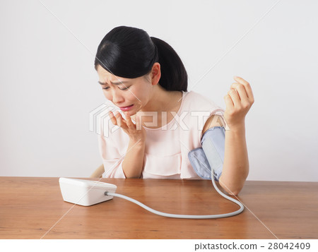 A woman surprised measuring blood pressure A woman surprised measuring blood pressure 28042409