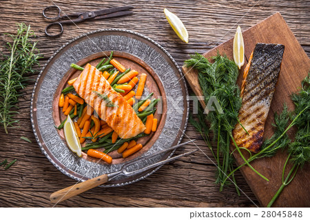 Grilled salmon, sesame seeds and herb decoration.  28045848