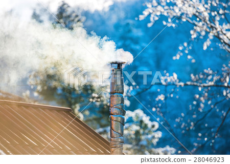 Smoke from the chimney on the roof 28046923